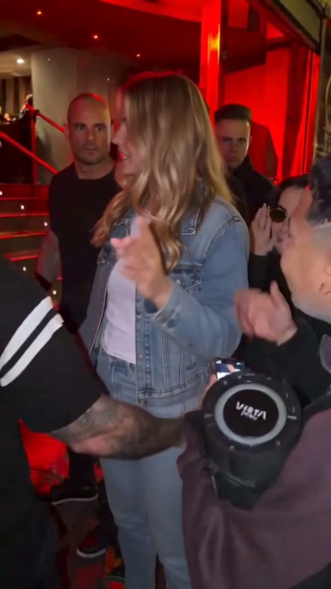 The rapper squaring up to Kevin Wai's speaker and phone at the red-lit entrance