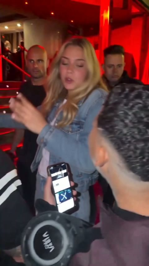 The rapper leaning in toward Kevin Wai's phone with both hands moving