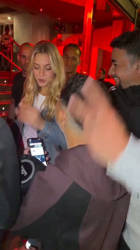 People crowding the venue doorway as a hand reaches into the frame