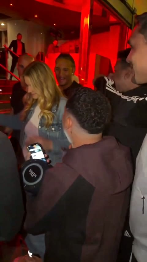 The rapper turning sideways and laughing with the man beside them