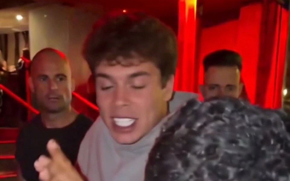 Young man in a gray hoodie in a Bulin 47 AI trend remake at the red-lit entrance